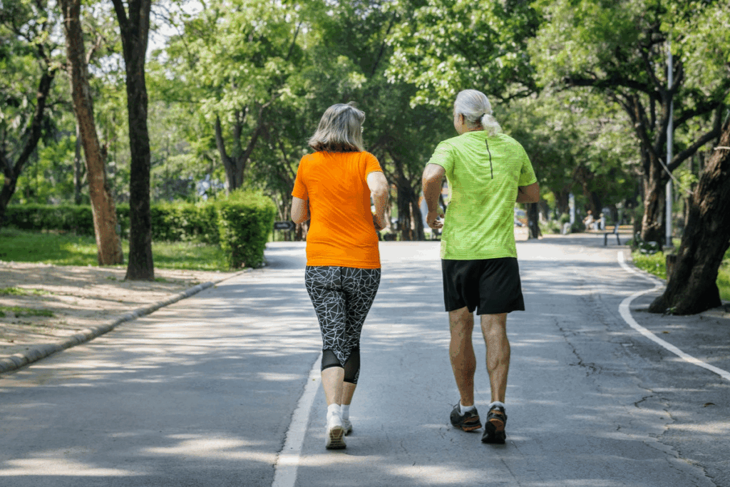 Two people walking together outdoors in activewear on a sunny day