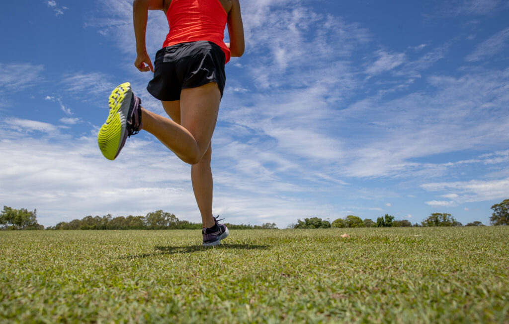 Athlete sprinting outdoors on a track during sunny weather