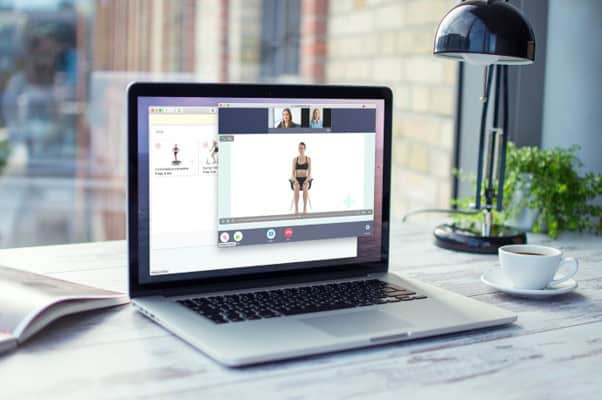 Person attending virtual fitness session on computer at home.