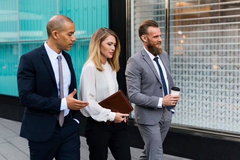 Group of professionals walking and discussing work outdoors