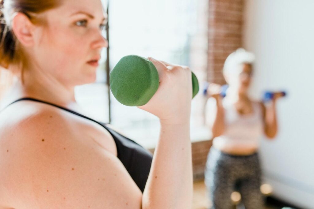 Woman holding a dumbbell and exercising indoors