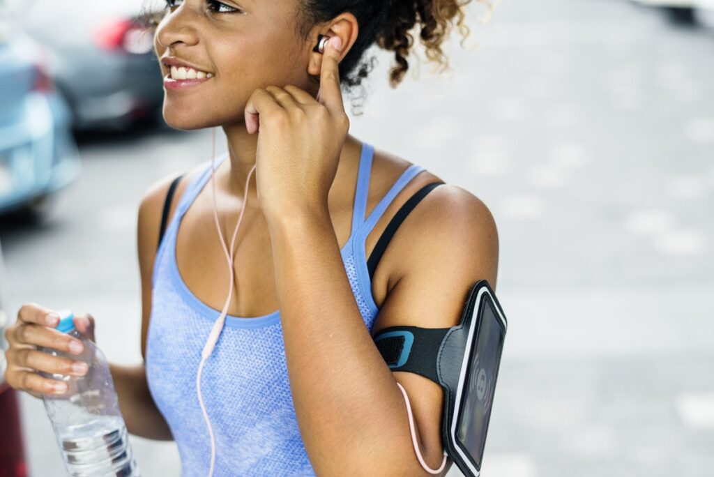 Smiling woman stretching her arms outdoors after morning workout