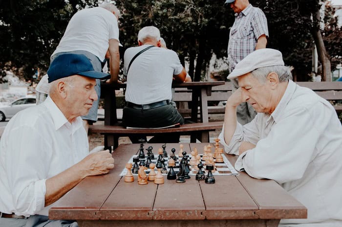 Group of elderly adults participating in seated exercise session with instructor