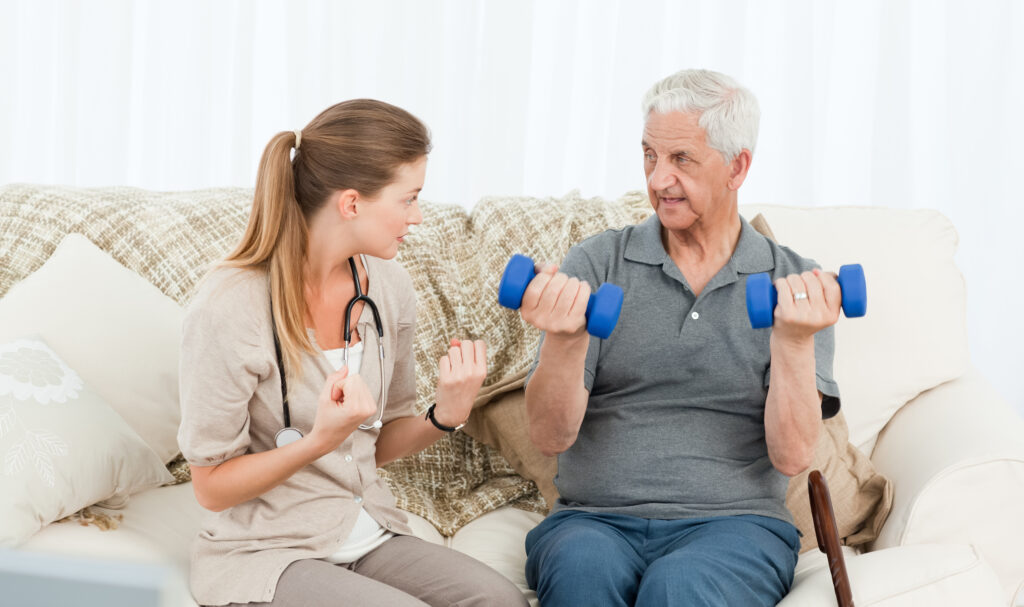 Older woman doing resistance band exercises with male physiotherapist