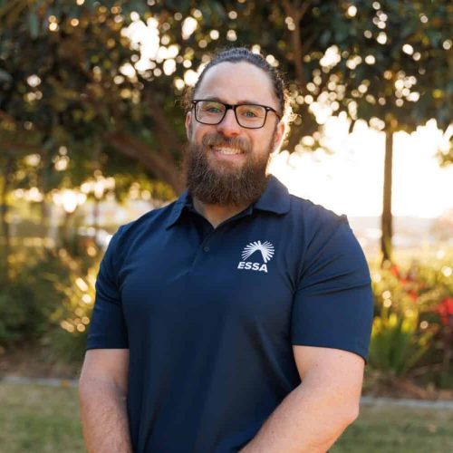 Male wearing ESSA shirt smiling outdoors